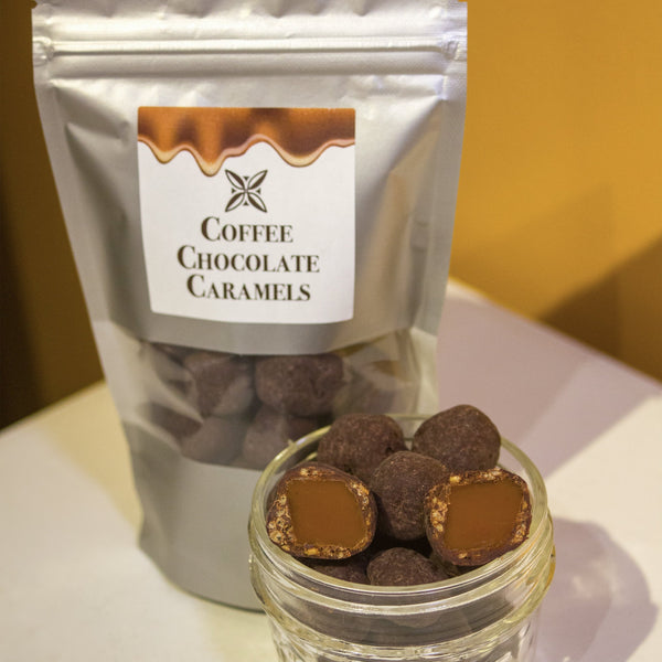 A bowl of caramels coated in chocolate and quinoa sits in front of a silver pouch with a label that says "coffee chocolate caramels"